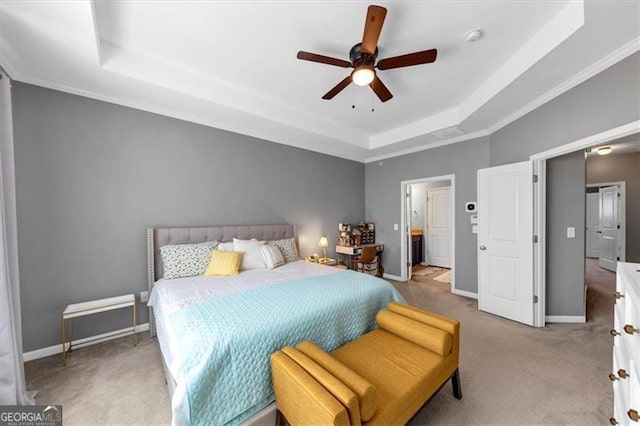 carpeted bedroom with a tray ceiling, ceiling fan, and crown molding