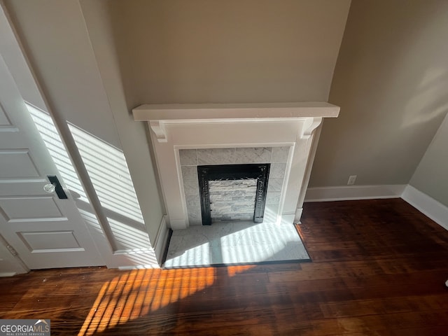 room details featuring hardwood / wood-style floors and a tiled fireplace