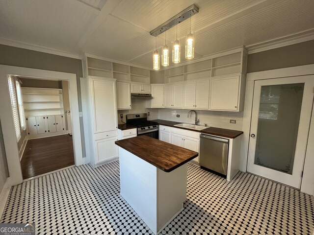 kitchen with stainless steel appliances, sink, white cabinets, a center island, and butcher block countertops