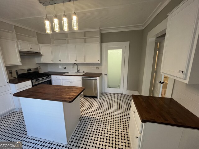 kitchen featuring appliances with stainless steel finishes, crown molding, sink, white cabinets, and a kitchen island