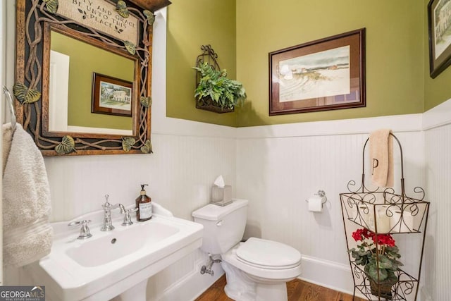 bathroom with toilet, hardwood / wood-style floors, and sink