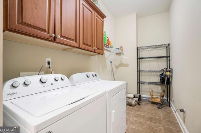 clothes washing area featuring cabinets and washer and dryer