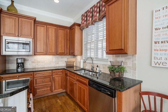 kitchen featuring sink, dark wood-type flooring, dark stone counters, appliances with stainless steel finishes, and ornamental molding