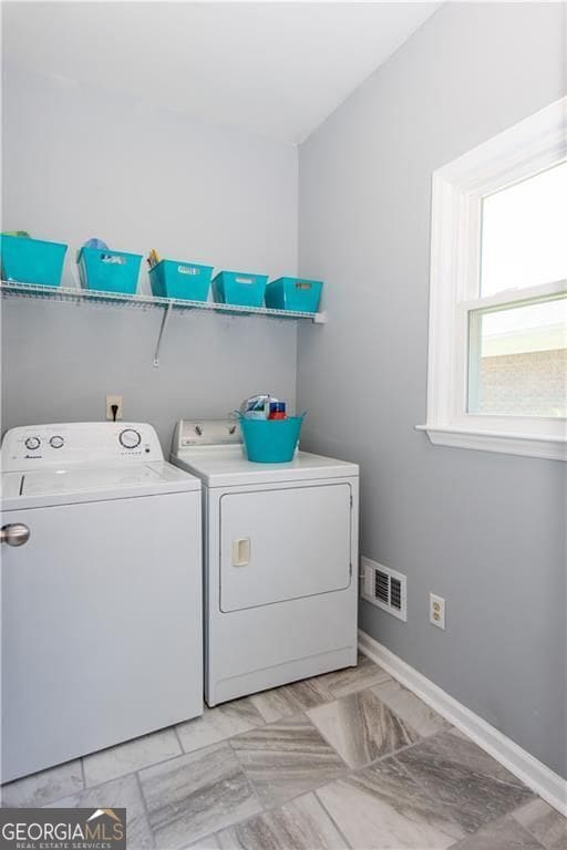 clothes washing area featuring separate washer and dryer