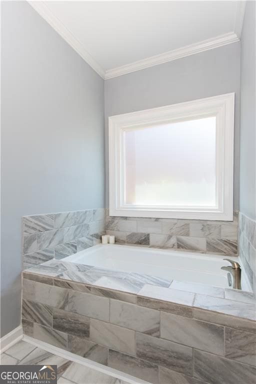 bathroom with a relaxing tiled tub, a healthy amount of sunlight, and crown molding