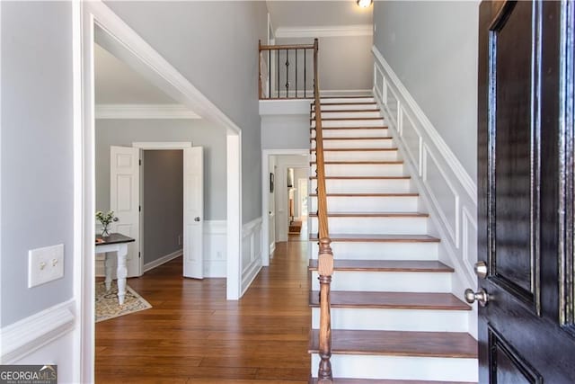 entrance foyer with crown molding and dark hardwood / wood-style floors