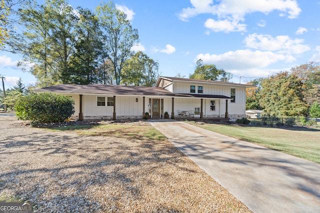 tri-level home with covered porch and a front lawn