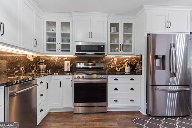 kitchen featuring white cabinets, stainless steel appliances, dark hardwood / wood-style floors, and dark stone counters