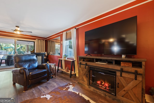 living room featuring ceiling fan, ornamental molding, and hardwood / wood-style flooring