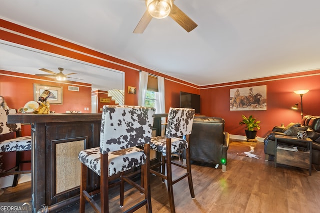 dining space featuring wood-type flooring and ornamental molding