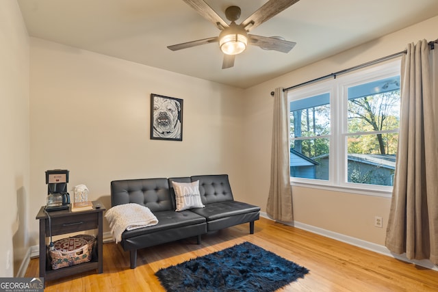 living area featuring wood-type flooring and ceiling fan