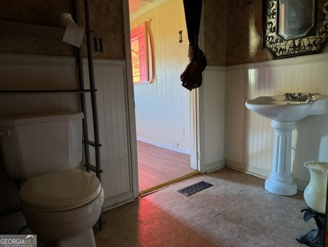 bathroom with toilet and tile patterned floors