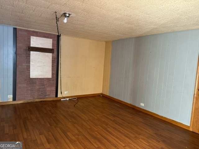 spare room with wood-type flooring and wooden walls