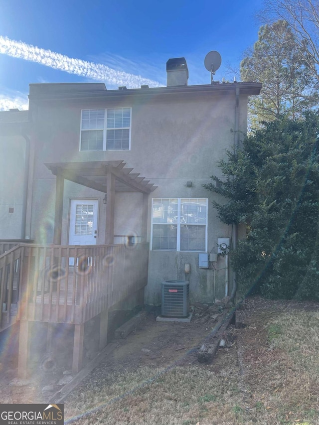 rear view of house with a pergola and central AC