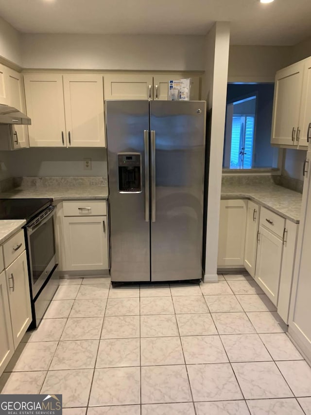 kitchen with white cabinets, appliances with stainless steel finishes, and light tile patterned floors