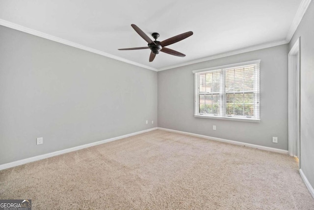 spare room with light colored carpet, ceiling fan, and crown molding