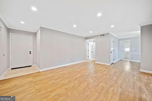 unfurnished living room featuring crown molding and light hardwood / wood-style flooring