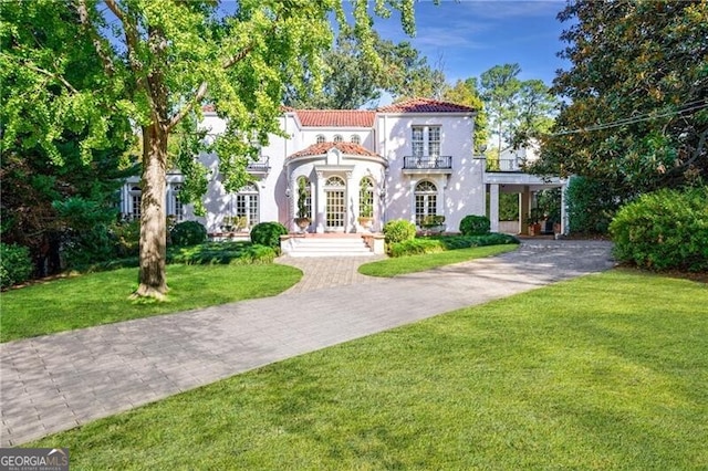 mediterranean / spanish-style home with a front yard and french doors