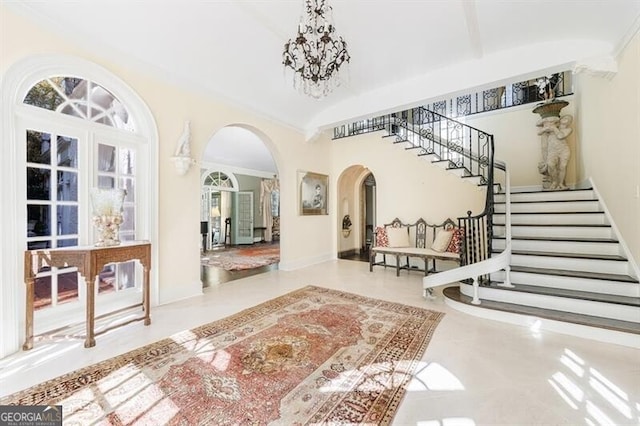 foyer featuring french doors, high vaulted ceiling, and a notable chandelier