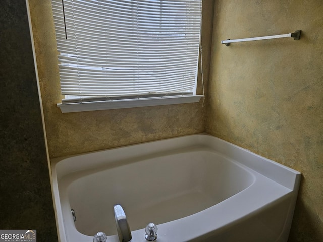 bathroom featuring a tub to relax in and a wealth of natural light