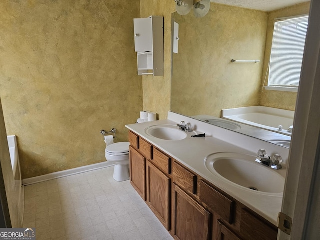 bathroom with vanity, toilet, and a tub