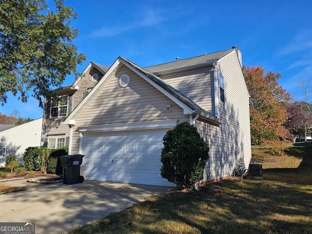 view of side of home featuring central AC unit, a garage, and a yard