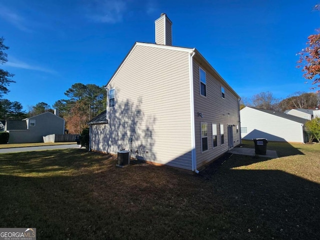 view of home's exterior with cooling unit and a lawn