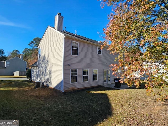 back of house with central AC and a yard