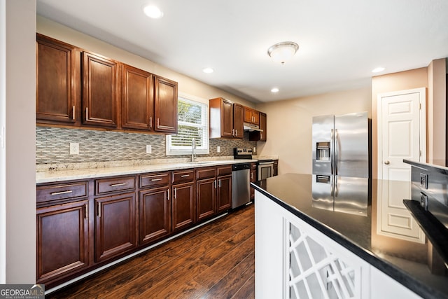 kitchen with decorative backsplash, appliances with stainless steel finishes, dark hardwood / wood-style floors, and sink