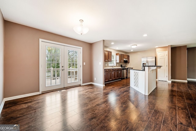 kitchen featuring appliances with stainless steel finishes, a center island, dark hardwood / wood-style flooring, and french doors