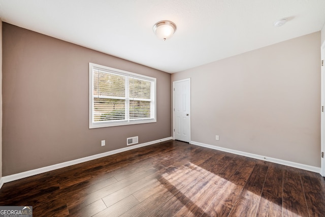 unfurnished room with dark wood-type flooring