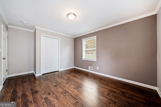 unfurnished bedroom featuring crown molding, a closet, and dark wood-type flooring