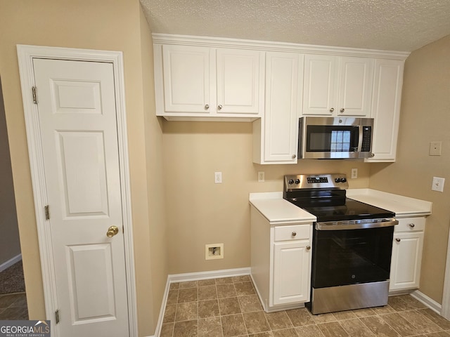 kitchen with white cabinets, stainless steel appliances, and a textured ceiling