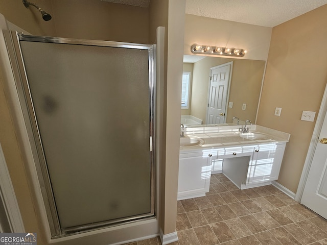 bathroom with vanity, a textured ceiling, and a shower with shower door