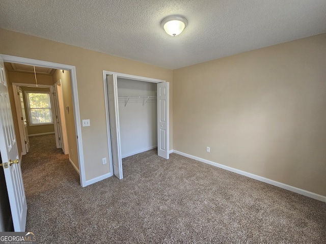 unfurnished bedroom featuring carpet flooring, a closet, and a textured ceiling