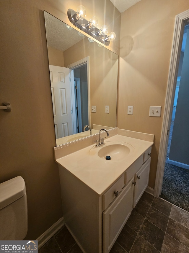 bathroom with vanity, a textured ceiling, and toilet