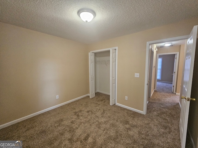 unfurnished bedroom featuring a textured ceiling, carpet floors, and a closet