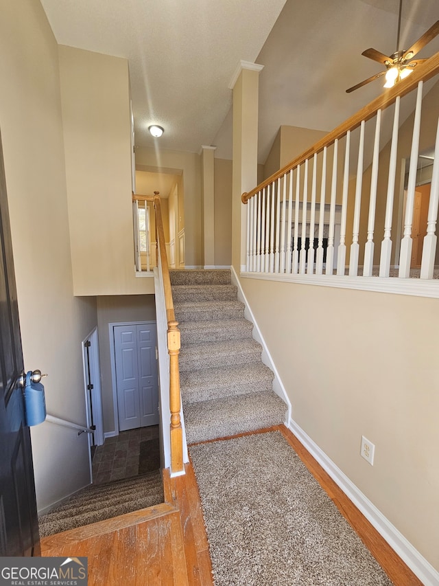 staircase featuring hardwood / wood-style flooring and ceiling fan