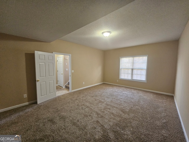 carpeted spare room featuring a textured ceiling