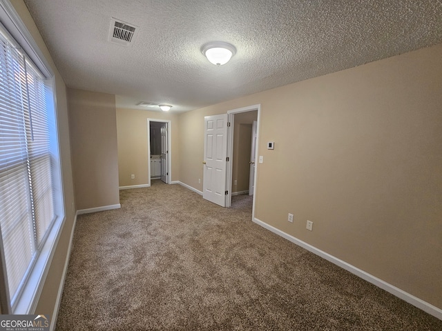 carpeted spare room featuring a textured ceiling