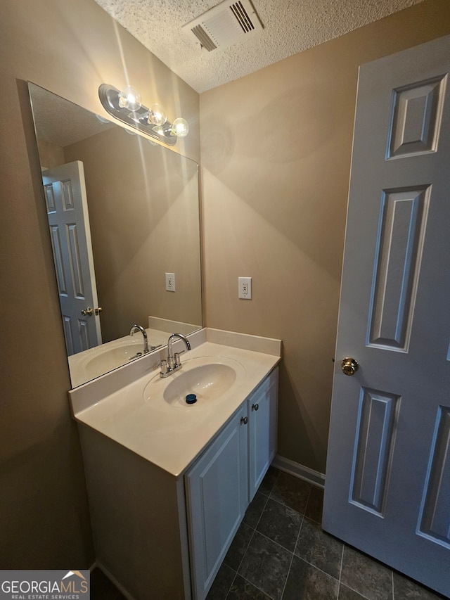 bathroom featuring tile patterned floors, vanity, and a textured ceiling