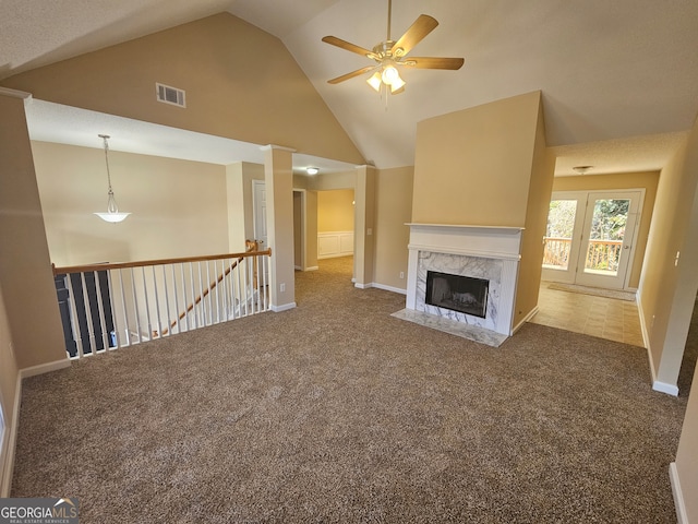 unfurnished living room with ceiling fan, carpet floors, a fireplace, and high vaulted ceiling