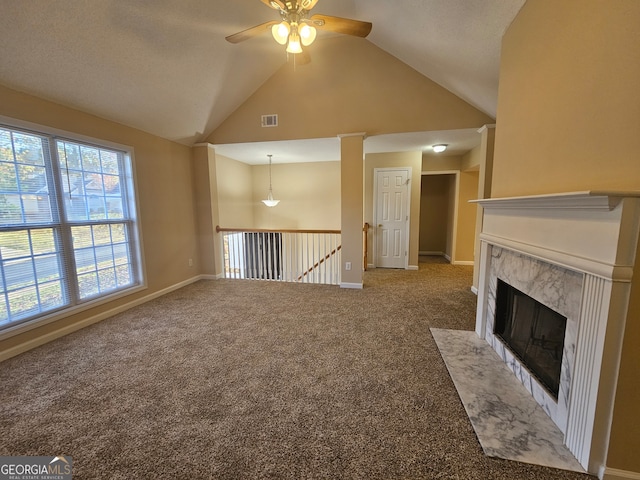 unfurnished living room featuring a fireplace, carpet flooring, high vaulted ceiling, and ceiling fan