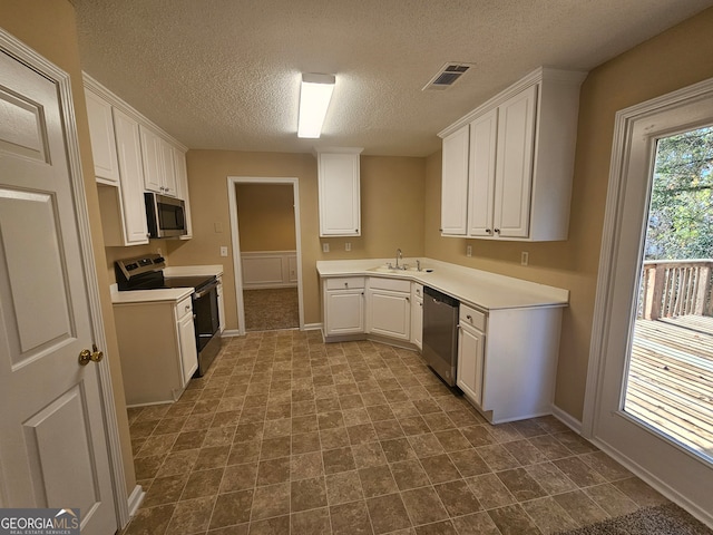 kitchen featuring white cabinetry, sink, a textured ceiling, and appliances with stainless steel finishes