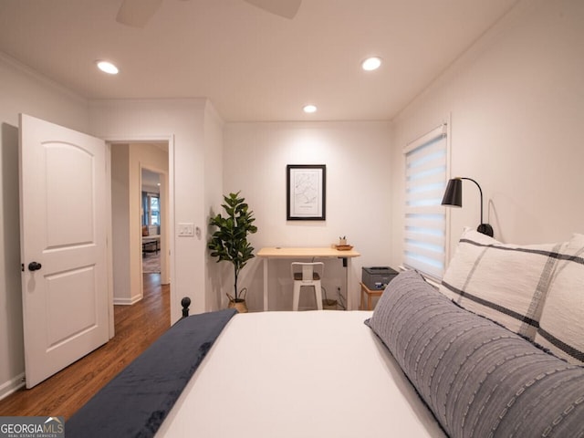 bedroom with crown molding, dark hardwood / wood-style flooring, and ceiling fan