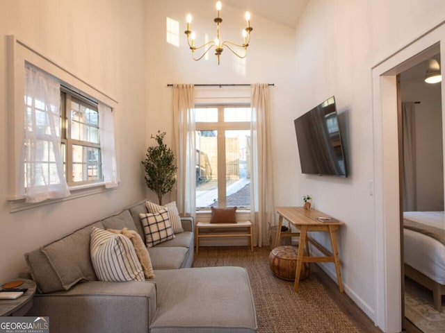 living room with high vaulted ceiling and an inviting chandelier