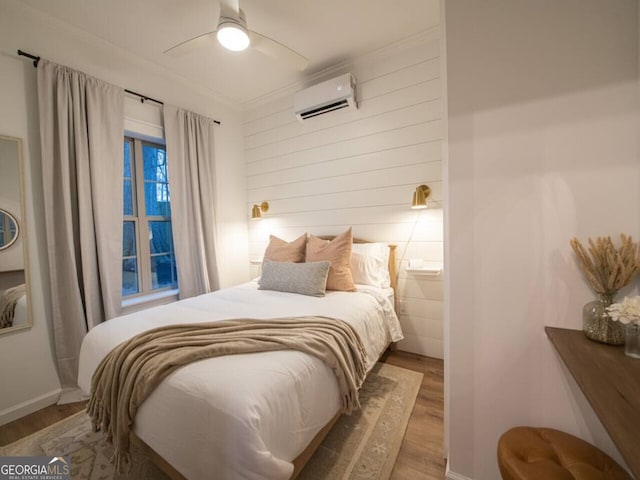 bedroom featuring hardwood / wood-style floors, a wall mounted AC, crown molding, and ceiling fan