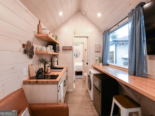 kitchen with wooden counters, black electric stovetop, wooden ceiling, light hardwood / wood-style floors, and lofted ceiling