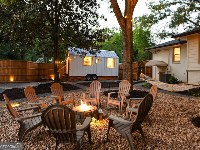 view of patio with an outbuilding, an outdoor fire pit, and central air condition unit