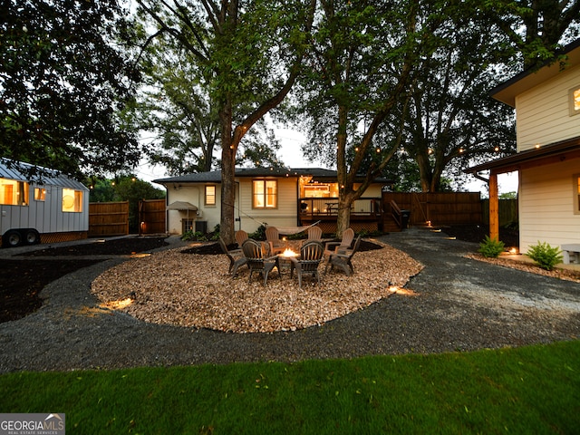 rear view of house with a wooden deck and an outdoor fire pit